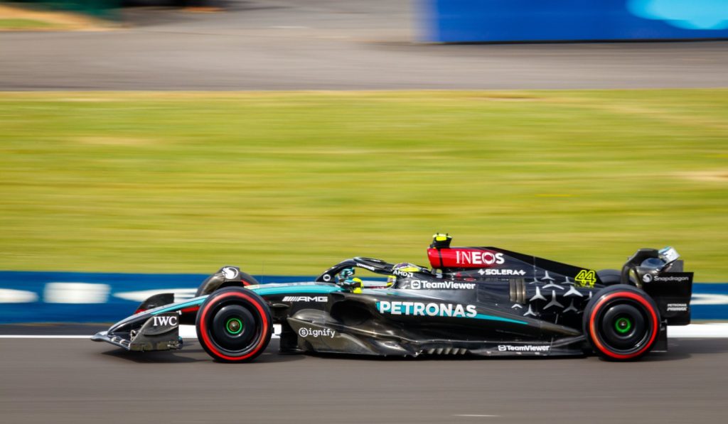 Lewis Hamilton drives the number 44 Mercedes Formula 1 car at speed on the Silverstone circuit.