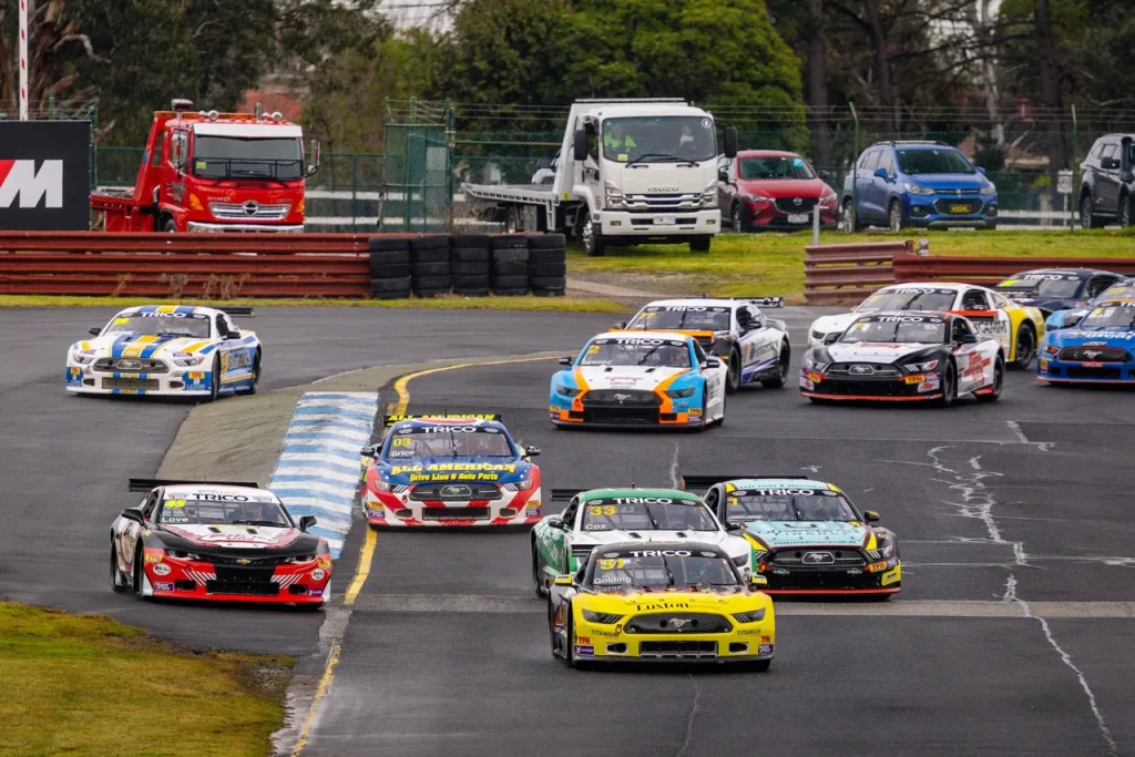 A pack of Trans Am racing cars cornering on an asphalt circuit.