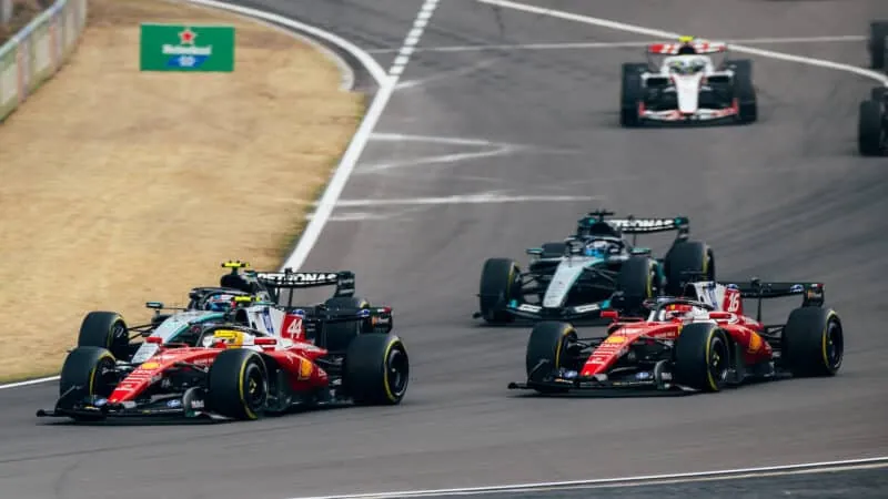 Formula 1 cars racing on an asphalt circuit.
