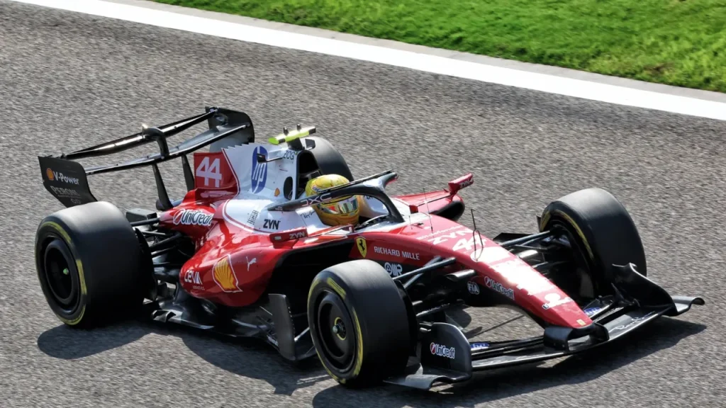 A red and white Formula 1 car on an asphalt racetrack.