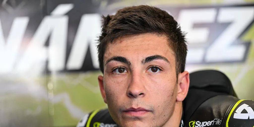 A close-up portrait of a motorcycle racer wearing racing leathers.
