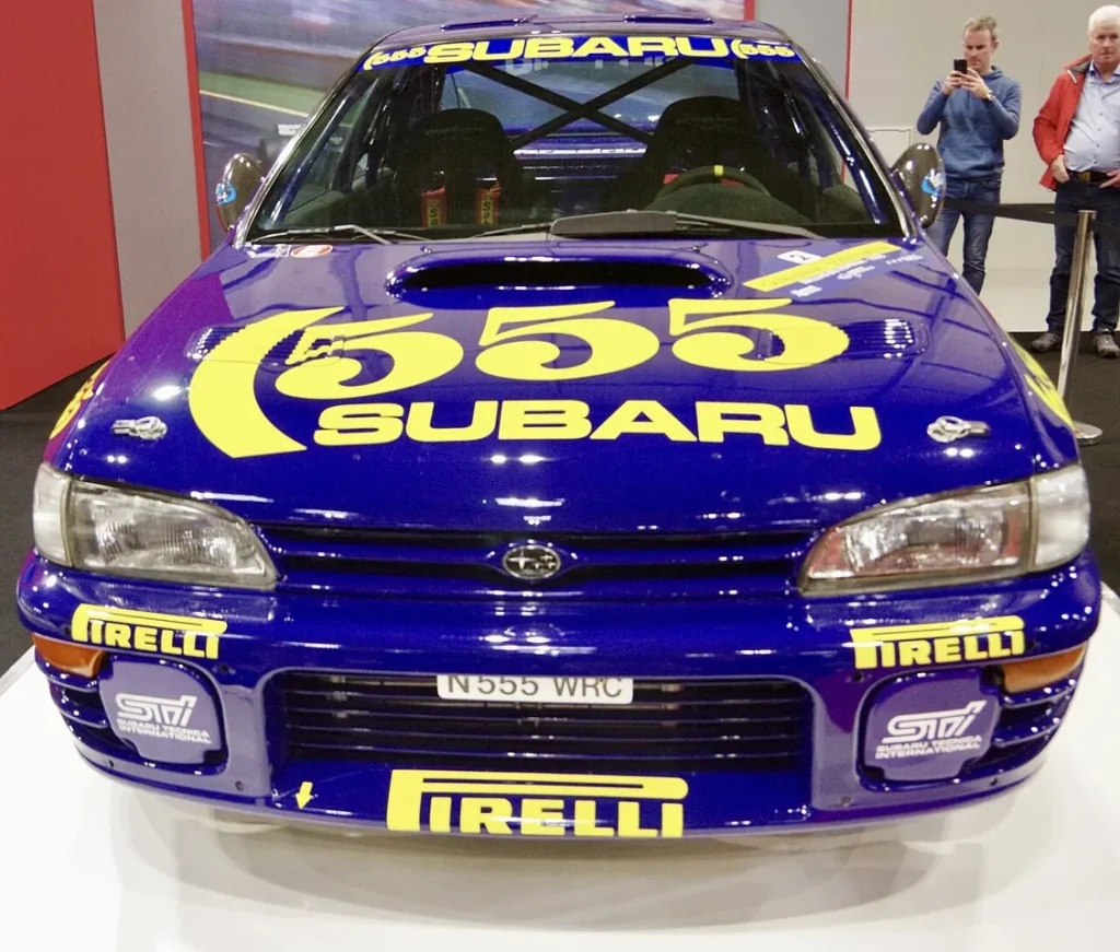 A rally car is on display indoors.