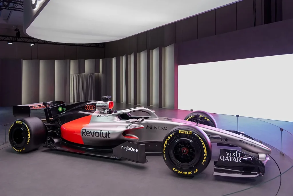 A silver, black, and red Formula 1 show car displayed indoors.