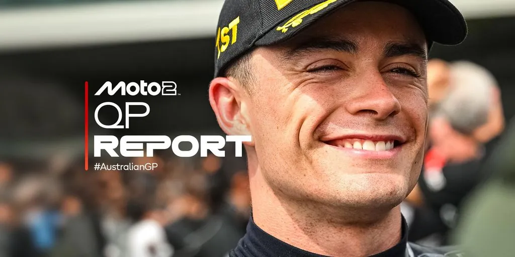 Close-up photograph of a smiling motorcycle racer wearing a black cap marked '1ST' on the side and a racing suit. On the left side of the frame is a graphic overlay reading 'Moto2 QP REPORT #AustralianGP'.