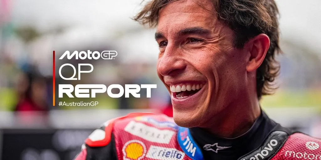 A motorcycle racer smiles while wearing racing leathers.